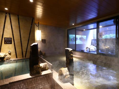 una piscina de agua con rocas en un edificio en Dormy Inn Express Fujisan Gotemba, en Gotemba