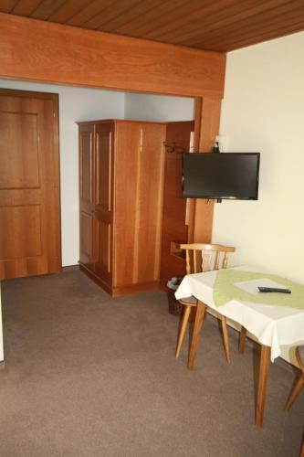 a room with a table and a cabinet and a tv at Haus Kristall in Bach