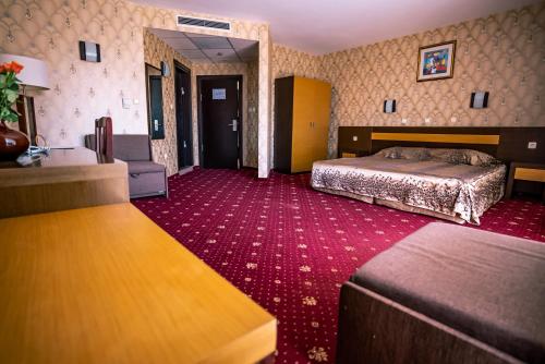 Habitación de hotel con cama y alfombra roja en Izola Paradise Hotel - All Inclusive, en Sunny Beach