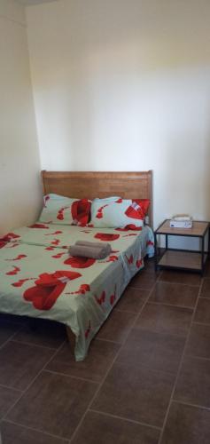 a bedroom with a bed with red flowers on it at Le Rahma in Sada