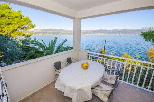 a balcony with a table and chairs and a view of the water at Apartments Dragica in Slatine