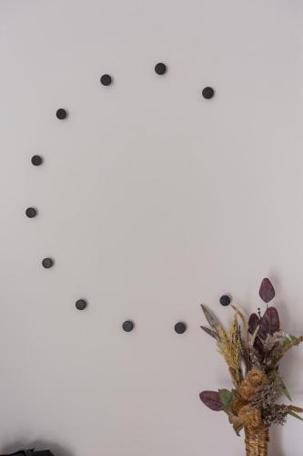 a vase with flowers on a white wall with grey dots at Casa in Centro in Nafpaktos