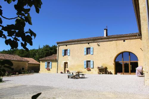 a building with a picnic table in front of it at Domaine de la Couderquié in Lautrec