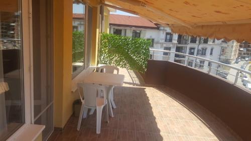 a balcony with a table and chairs on a building at Valemar Apartments in Pomorie