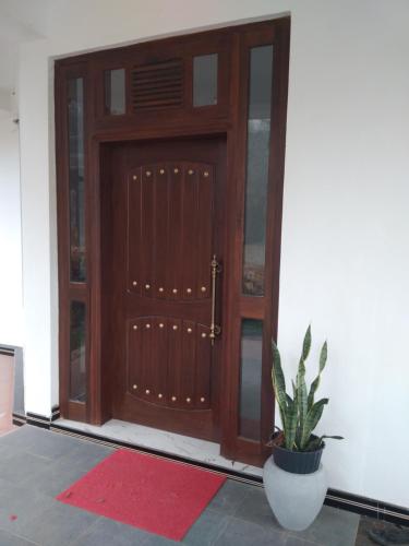 a wooden door with a potted plant in front of it at Holly House Homestay in Ella