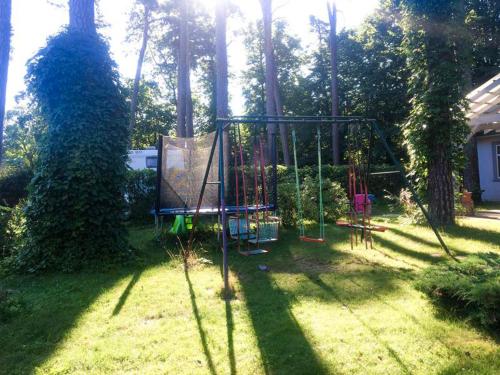 a swing set in a yard with trees at Valensija - Suite for two in nice hotel in Jūrmala