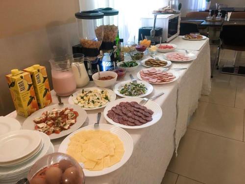 a buffet of food on a table with plates of food at Valensija - Suite for two in nice hotel in Jūrmala