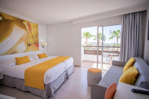 a hotel room with two beds and a balcony at Servatur Waikiki in Playa del Ingles