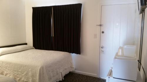 a bedroom with a bed and a black window at Rocket Motel in Custer
