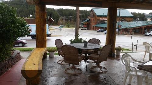a table and chairs on a porch in the rain at Rocket Motel in Custer