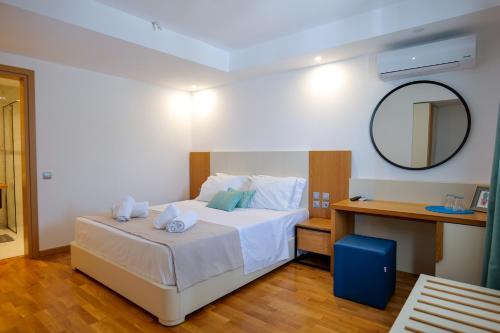 a bedroom with a white bed and a mirror at Royal 1967 in Himare
