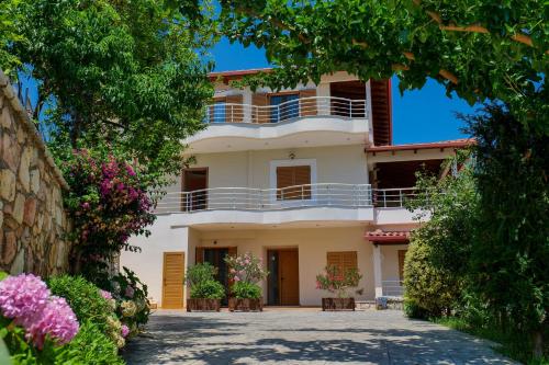 a large white house with balconies and flowers at Royal 1967 in Himare