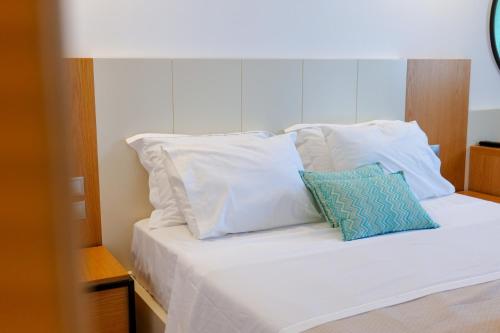 a white bed with two pillows on it at Royal 1967 in Himare