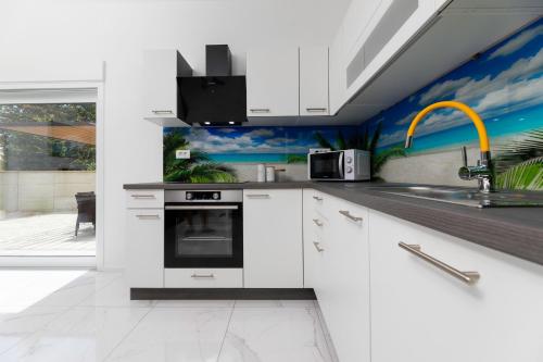 a kitchen with white cabinets and a sink at Villa Veroniq in Županje
