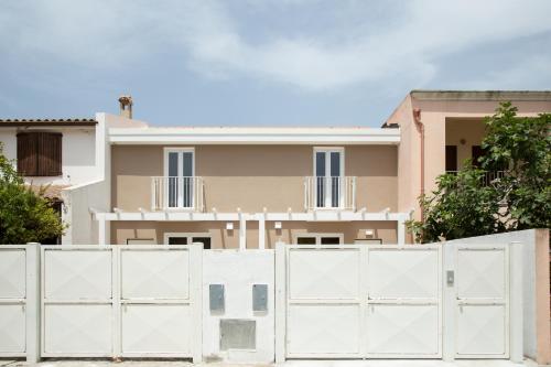 Pula Residence - Via Delle Rose في بولا: سور أبيض أمام المنزل