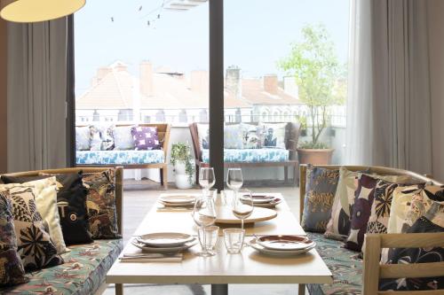 a dining table with wine glasses and a couch at Mama Shelter Lyon in Lyon
