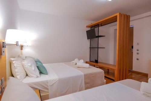 a hotel room with two beds and a mirror at Royal 1967 in Himare