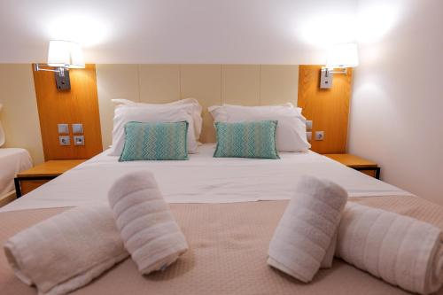 a bedroom with a large white bed with two pillows at Royal 1967 in Himare