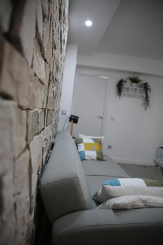 a room with two beds and a brick wall at CASA SIMÓN in Albarracín