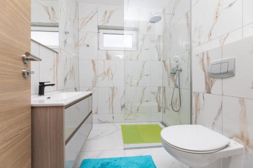 a bathroom with a toilet and a sink and a shower at Villa Veroniq in Županje
