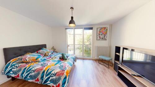 une chambre avec un lit et une télévision dans l'établissement Superbe appartement au cœur du centre ville, à Caen
