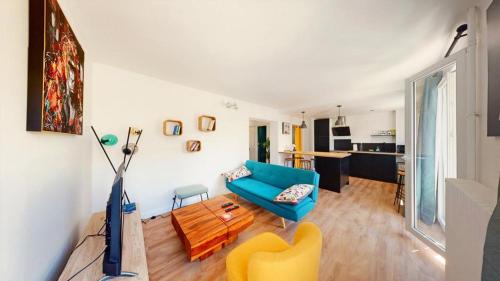 a living room with a blue couch and a yellow chair at Superbe appartement au cœur du centre ville in Caen