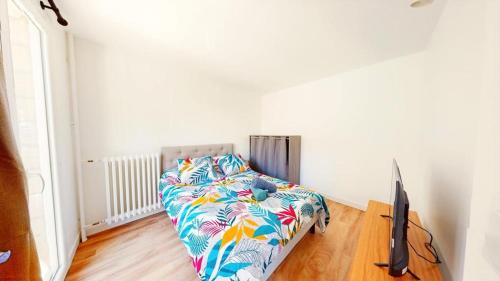 a bedroom with a bed and a flat screen tv at Superbe appartement au cœur du centre ville in Caen