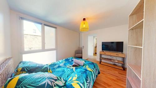 a living room with a couch and a flat screen tv at Superbe appartement au cœur du centre ville in Caen