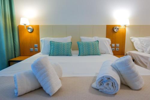 a bedroom with a large white bed with towels on it at Royal 1967 in Himare