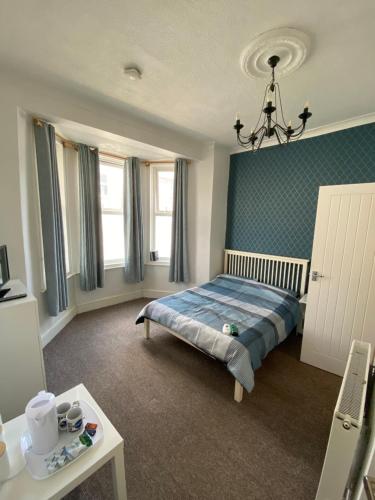 - une chambre avec un lit et un lustre dans l'établissement The Bay En-suite Room, à Plymouth