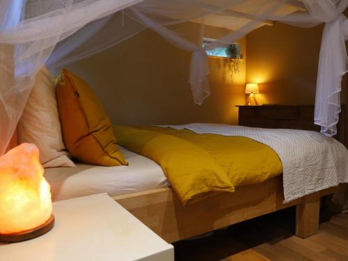 a bedroom with a bed with a yellow comforter at The Sunbird Inn - with luxurious bathroom & sauna in Diessen