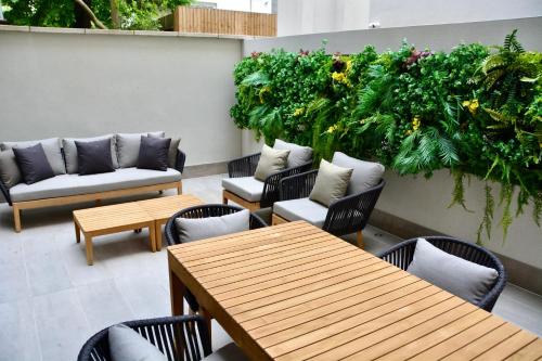 een patio van het restaurant met tafels, stoelen en planten bij Sanctum Regent's Park in Londen