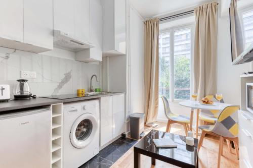 une cuisine avec une machine à laver et une table dans l'établissement New and quiet 1 Bdr Flat in the Heart of Paris 12, à Paris