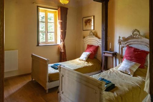 two twin beds in a room with a window at Haute Dône in Luzy