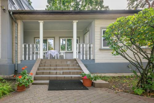 a house with stairs and a table and chairs at Valensija - Large Suite apartment in Jūrmala