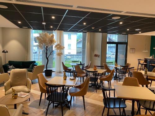 a restaurant with tables and chairs in a cafeteria at DOMITYS L'HOROLOGIA in Cluses