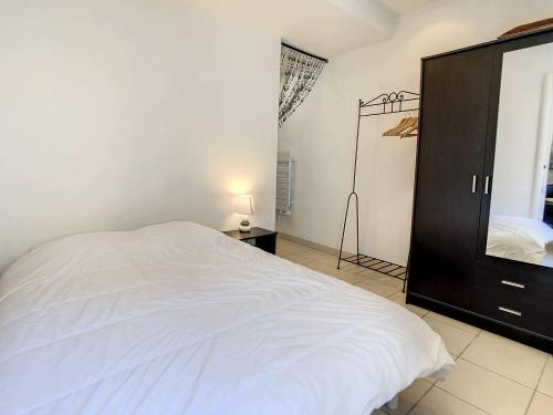 une chambre avec un lit blanc et une armoire noire dans l'établissement 1 Bedroom Notre Dame 2 mins from the Croisette and the Palais 225, à Cannes