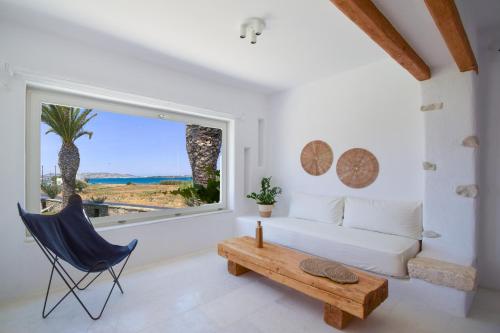 a living room with a white couch and a large window at SUNSET POUNDA LUXURY VERSION in Pounda