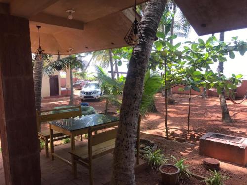 a porch with a bench and an umbrella at Kizhunna rock beach house in Kannur