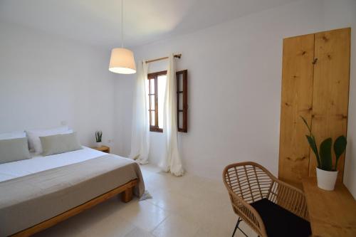 a bedroom with a bed and a chair and a window at SUNSET POUNDA LUXURY VERSION in Pounda