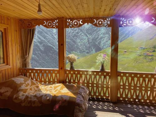 a bedroom with a window with a view of a mountain at Guesthouse Kvavlo in Kvavlo