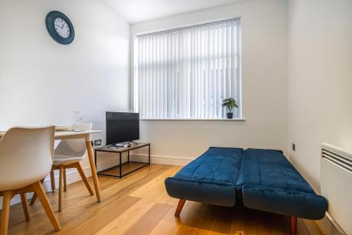 a living room with a blue ottoman in front of a desk at 10080 Luxury Apartment near Luton town Mall in Luton