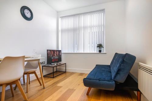 sala de estar con silla azul y mesa en 10080 Luxury Apartment near Luton town Mall en Luton