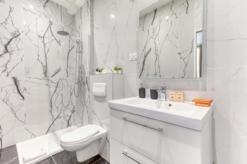une salle de bain blanche avec un lavabo et une douche dans l'établissement New and quiet 1 Bdr Flat in the Heart of Paris 12, à Paris