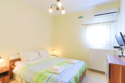 a bedroom with a bed with towels on it at Captain Alex Villa 1 in Dafnila