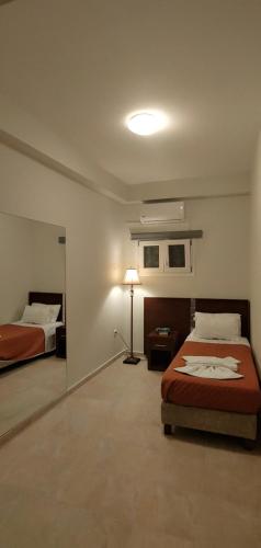 a bedroom with two beds and a lamp in it at Captain Alex Villa 1 in Dafnila