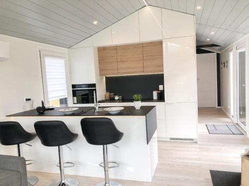 a kitchen with black chairs and a kitchen island at Luxus Ferien-Lodge Lurger-Fasching in Rohrbach An Der Gölsen