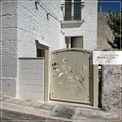 eine Tür mit Blumendesign neben einem Gebäude in der Unterkunft DIMORE Fanizza in Alberobello