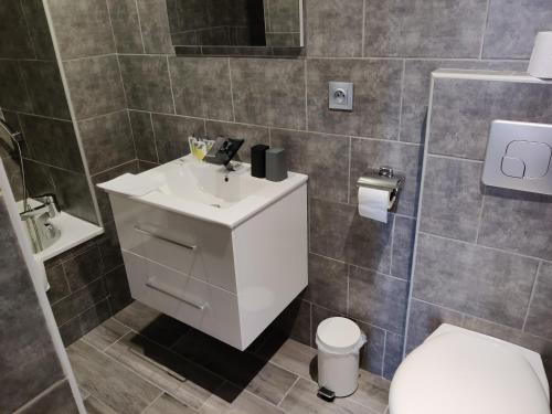 a bathroom with a white sink and a toilet at Hotel Les Voyageurs - Vogüé in Vogüé