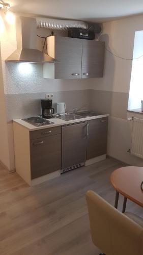 een kleine keuken met een spoelbak en een fornuis bij Ferienwohnung Höhn in Kitzingen
